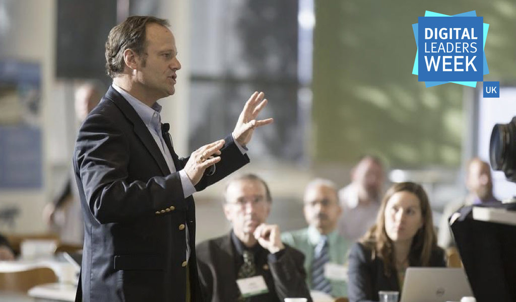 Man speaking to a group of people in a discussion forum