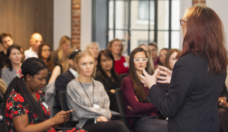 Woman speaking to a crowd at a salon, Diversity in Tech
