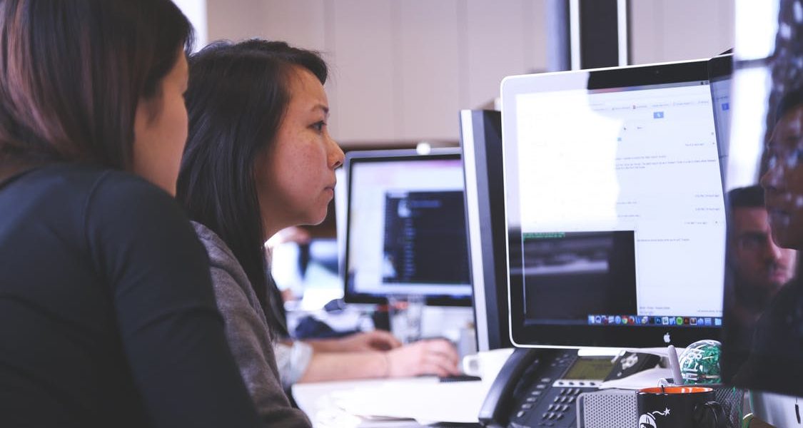 Young people using digital skills and technology on computer