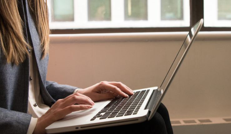 Woman using a laptop in the fintech industry, from #WOCinTech Chat