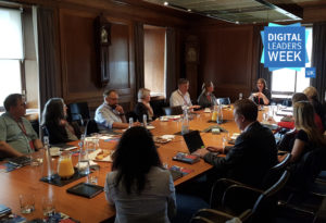 large boardroom with seated professionals discussing topics