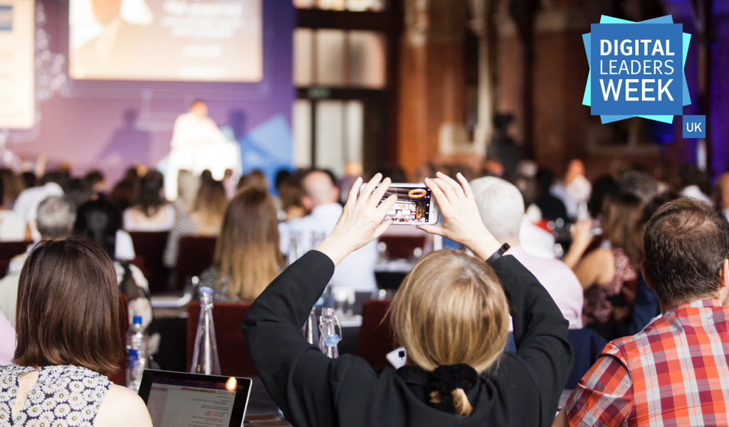 large event, woman taking photo of the projector screen