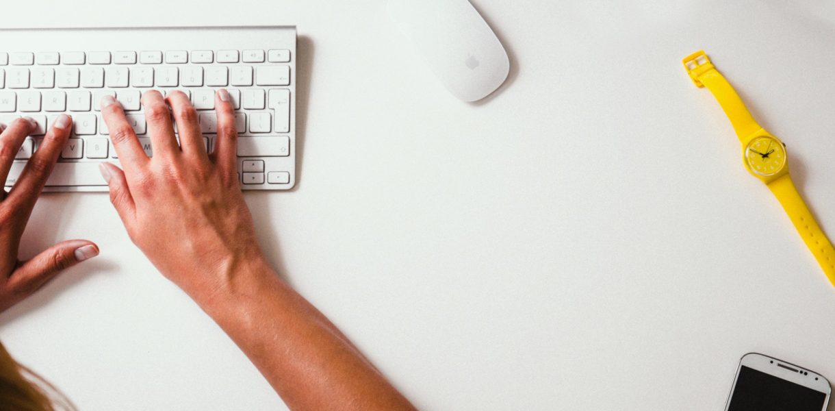 hands typing on a mac keyboard