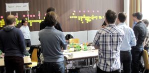 People working at a desk with post it notes and planning user story journeys