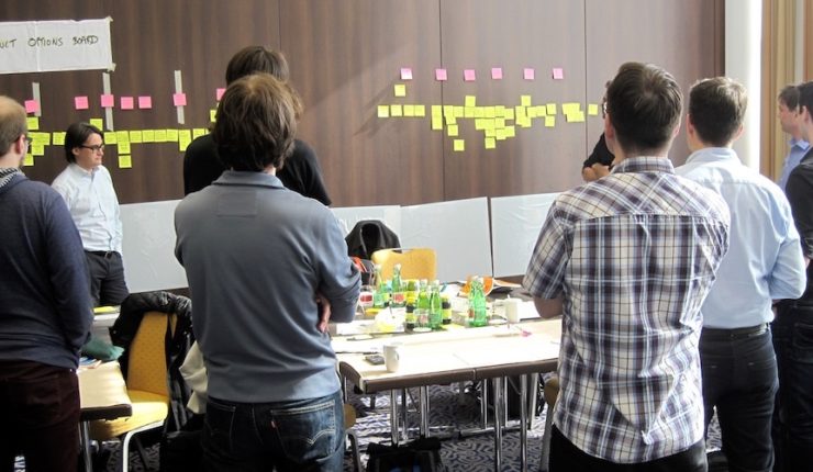 People working at a desk with post it notes and planning user story journeys