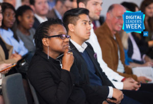 Woman in a crowd listening intently at a Digital Policy conference