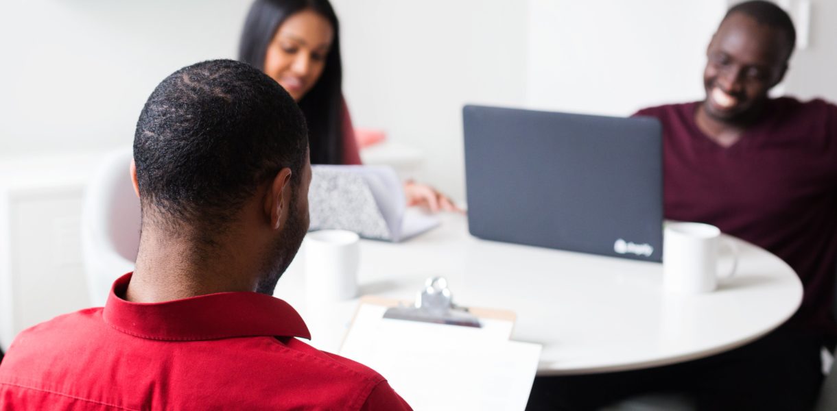 People networking around a table with a laptop