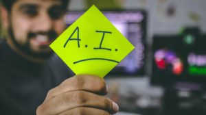 AI programmer holding up sign saying AI