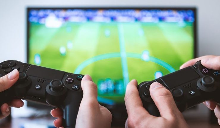People using video game controllers to play fifa
