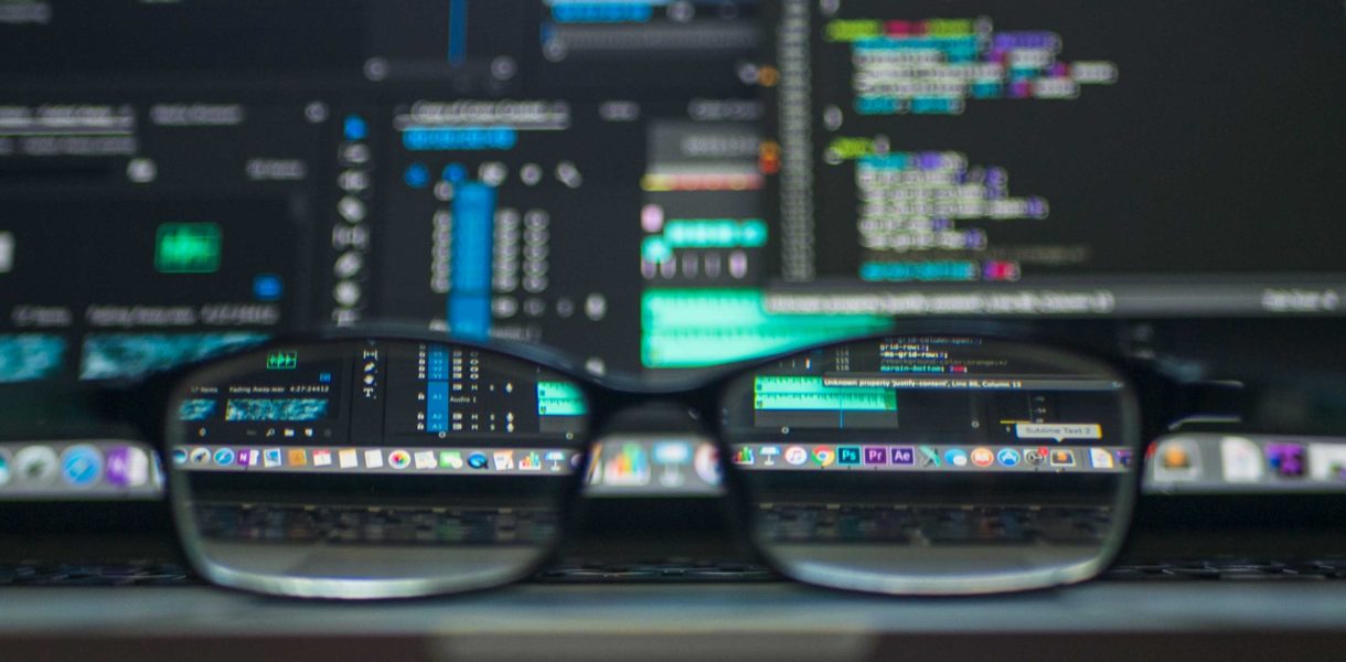 Artificial Intelligence algorithm code blurred out, but glasses lens clarifying a part of the image