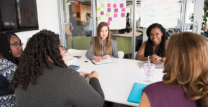 Team of women gathered around a board table