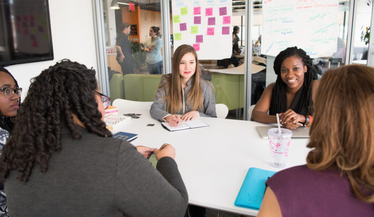 Team of women gathered around a board table