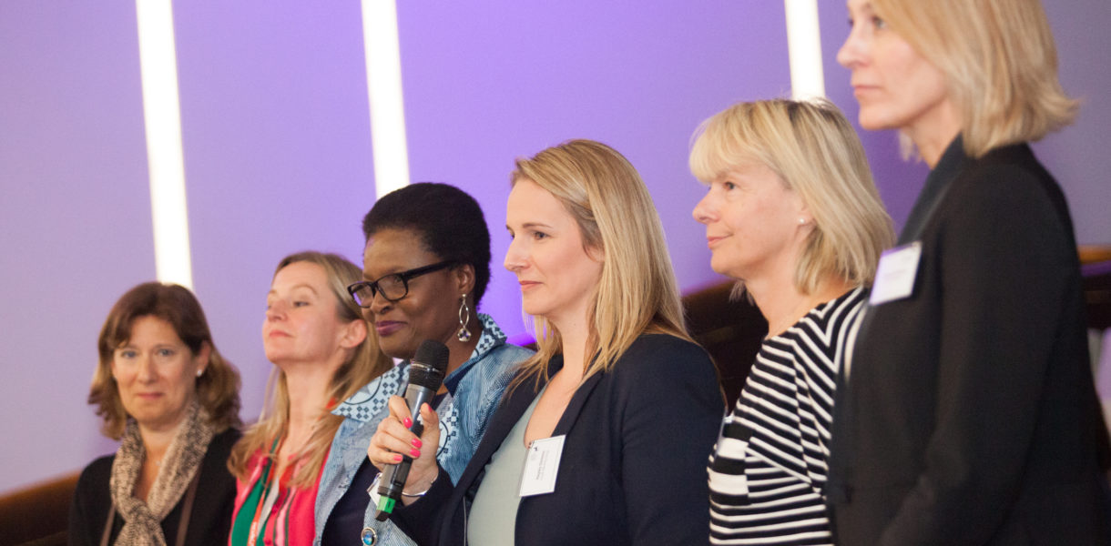 Women in a line at the BODIT Women in Tech hackathon discussing imposter syndrome