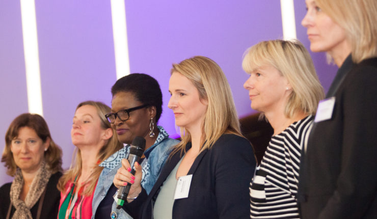 Women in a line at the BODIT Women in Tech hackathon discussing imposter syndrome