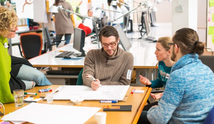 Team sitting around a table working on a project together