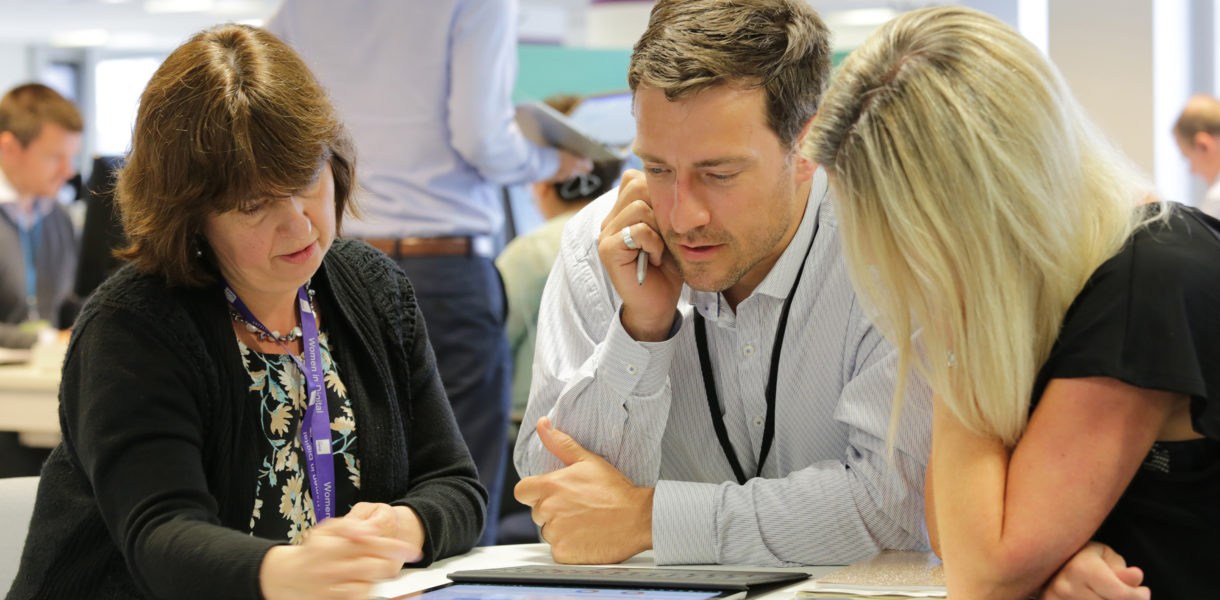 3 people around a table discussing digital strategy