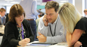 3 people around a table discussing digital strategy