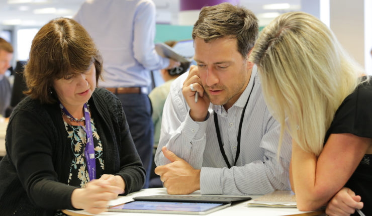 3 people around a table discussing digital strategy