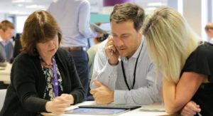 3 people around a table discussing digital strategy