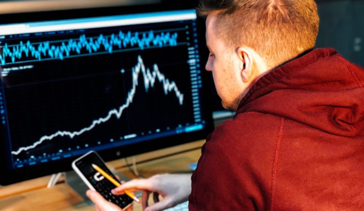 Guy using blockchain technology to look at bitcoin on a computer and mobile