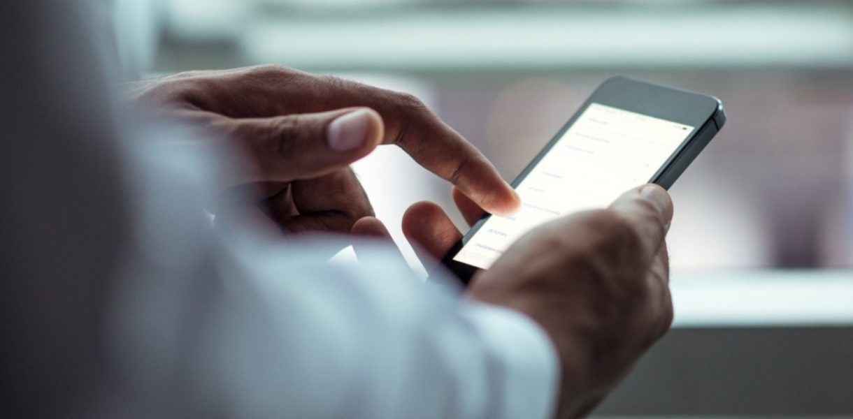 Man in a business suit using an iphone