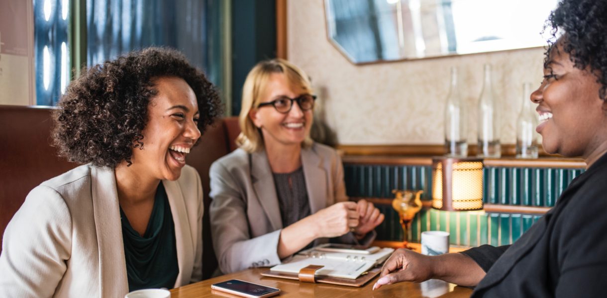 three women around a table in a business meeting