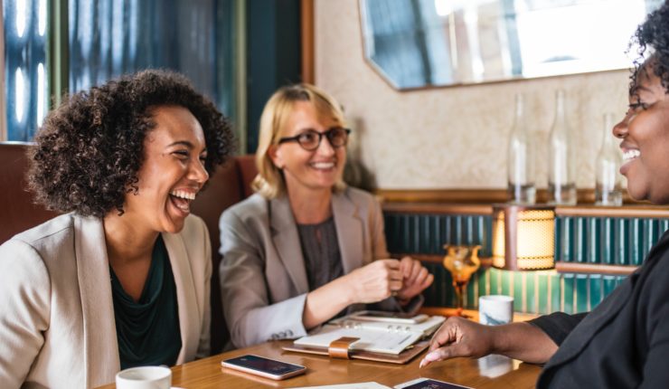 three women around a table in a business meeting