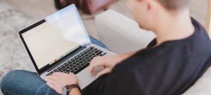 Man typing on a laptop using a public website