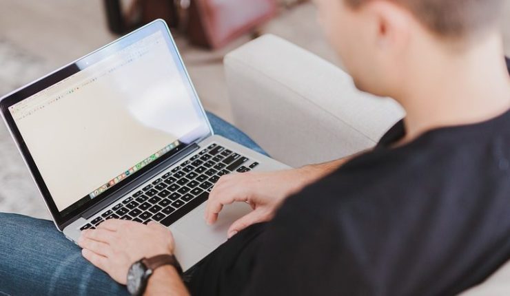 Man typing on a laptop using a public website