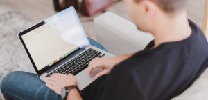 Man typing on a laptop using a public website