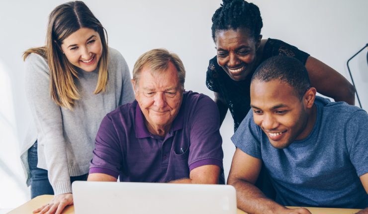 Diverse group of people looking at a computer