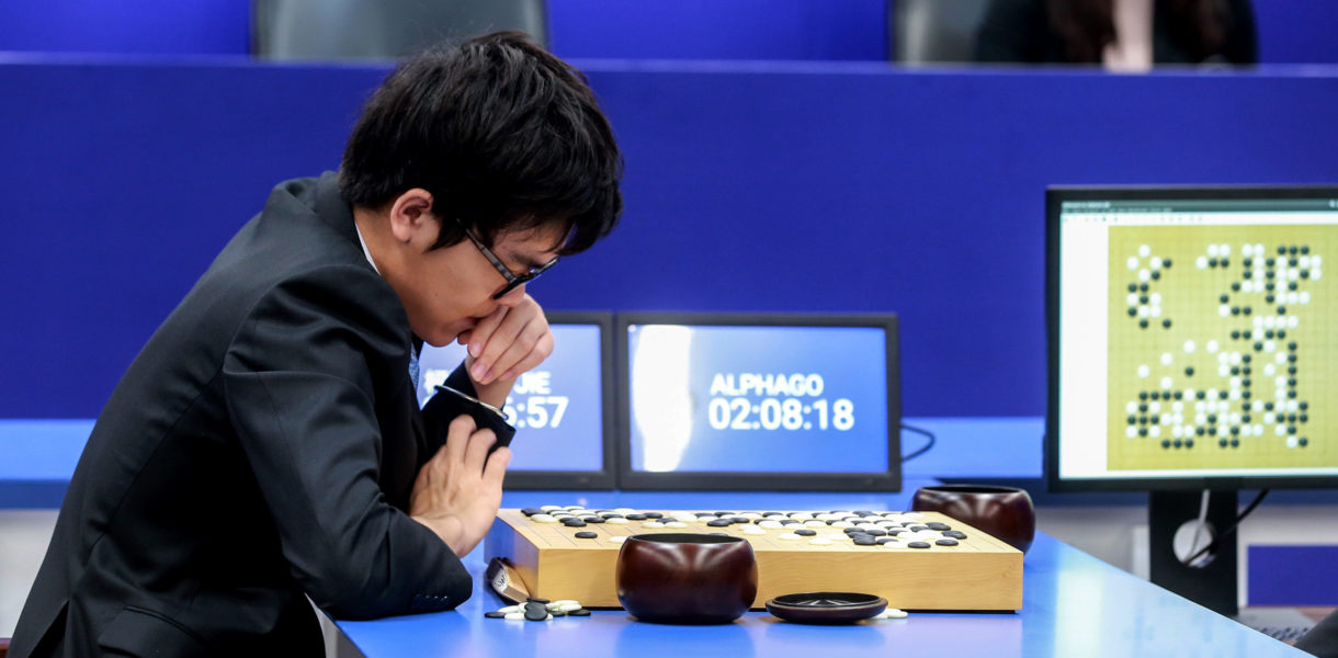 Boy sitting at tabel playing AlphaGo