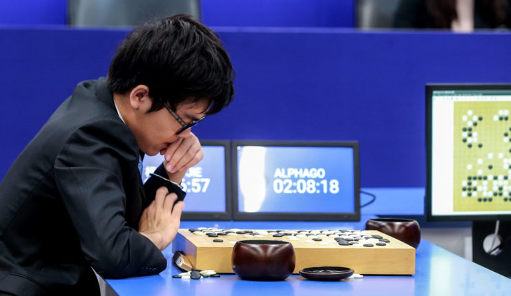 Boy sitting at tabel playing AlphaGo