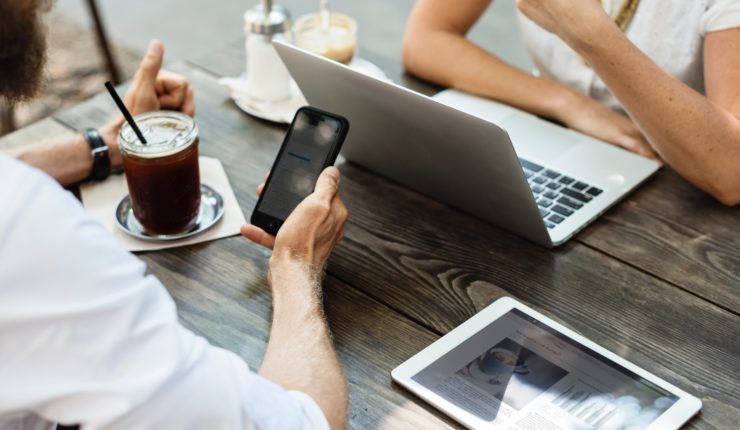 man using mobile and woman using computer