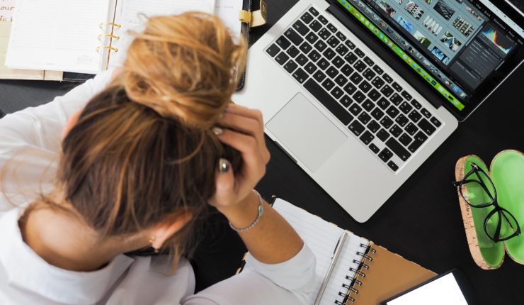 woman using computer and taking notes