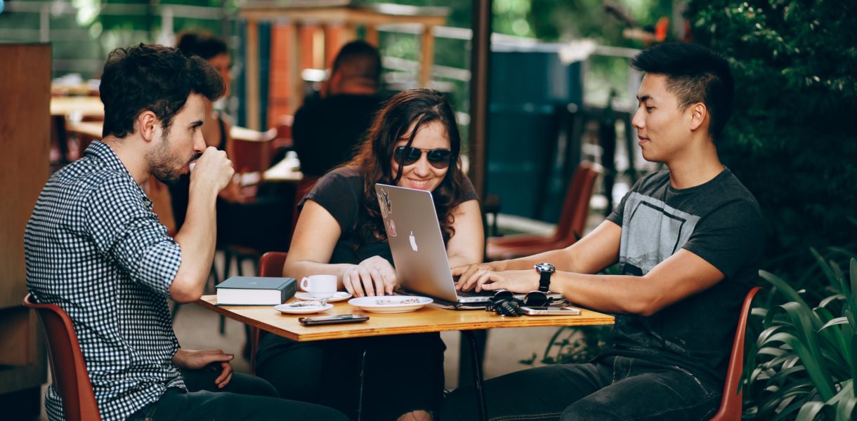 Students looking at laptop around table
