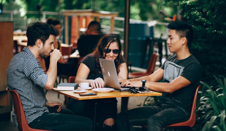Students looking at laptop around table