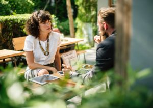 Man and woman sitting around laptop discussing