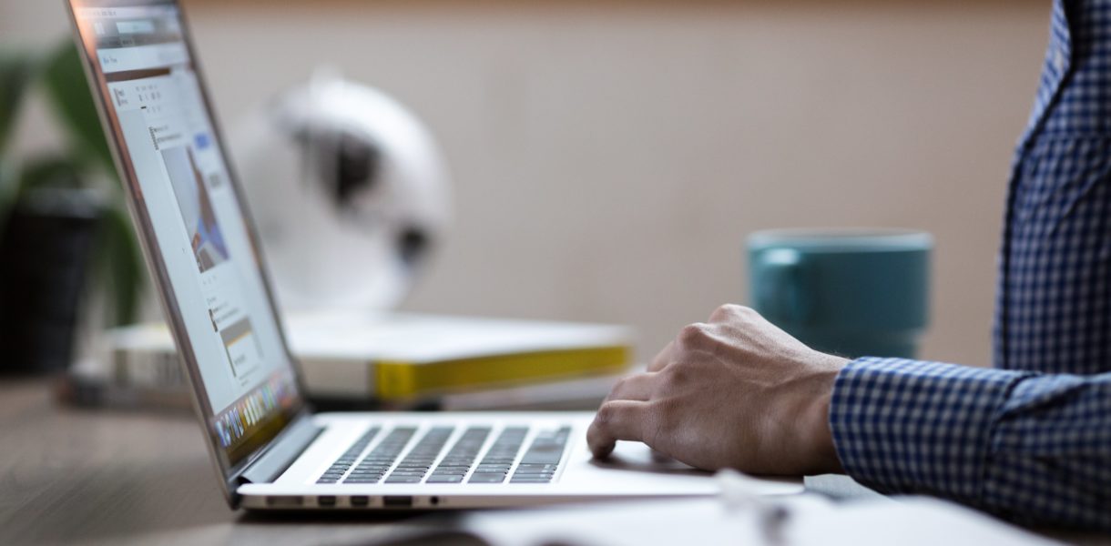 Man sitting at test and typing on computer
