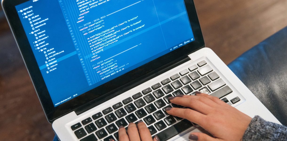 hands typing code on computer
