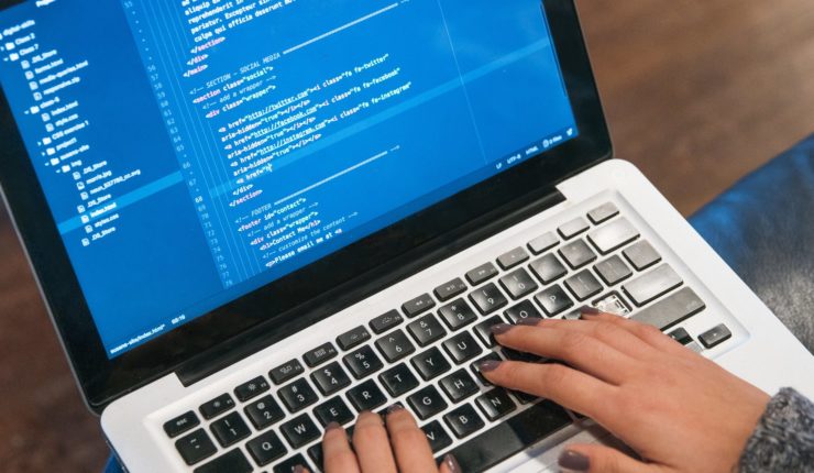 hands typing code on computer