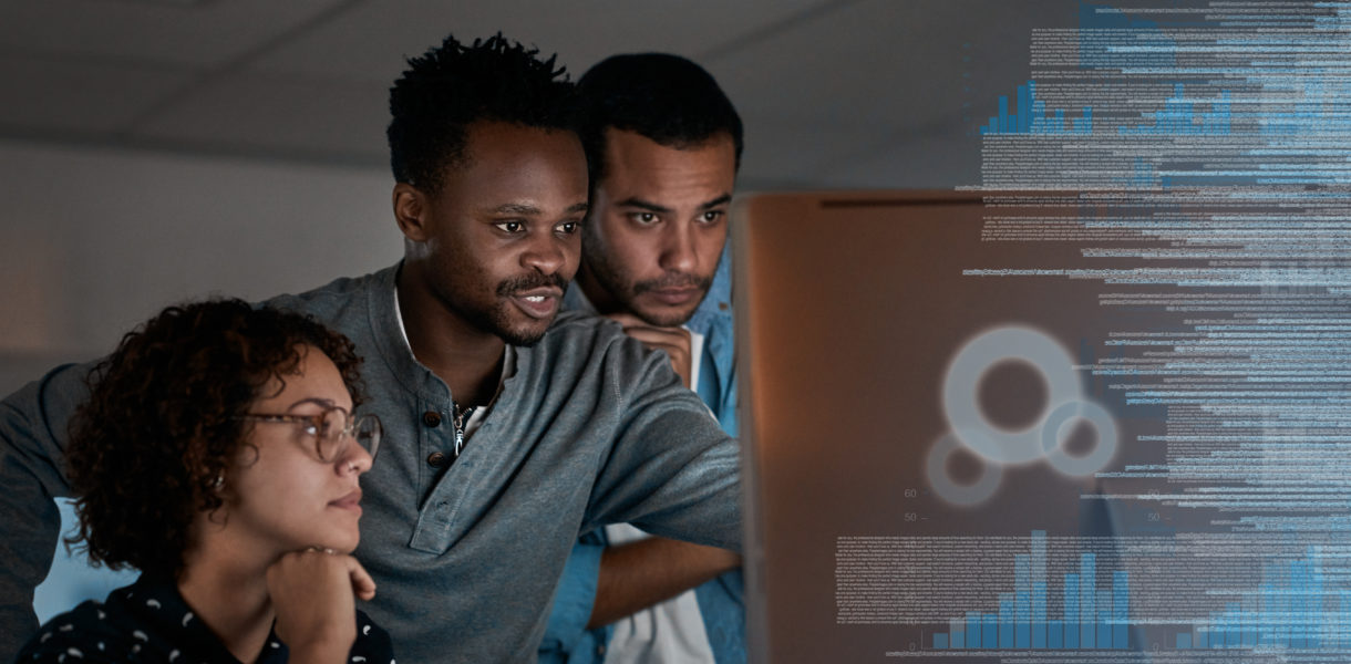 a group of programmers working together on a computer code at night