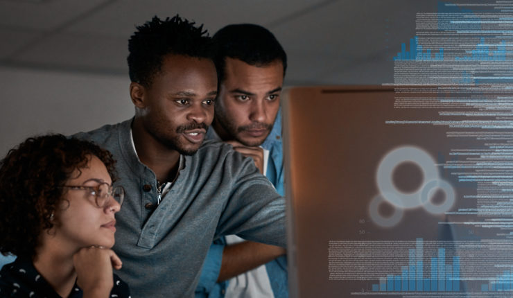 a group of programmers working together on a computer code at night