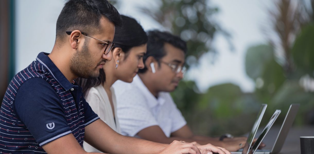 women and men working on computer outside