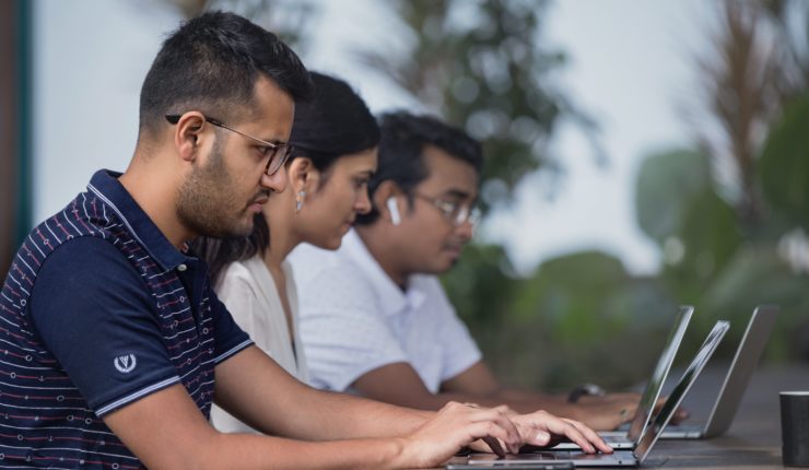 women and men working on computer outside