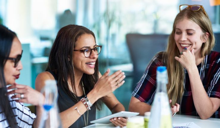 Three women sitting at table talking