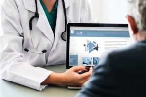 Doctor using computer to show something to a patient