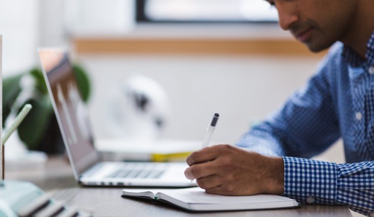 Man using computer and note pad