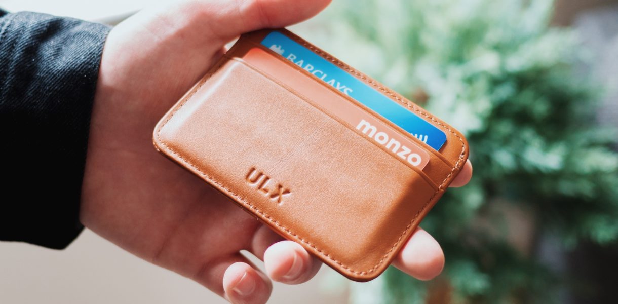 Man holding wallet with Monzo and Barclays cards