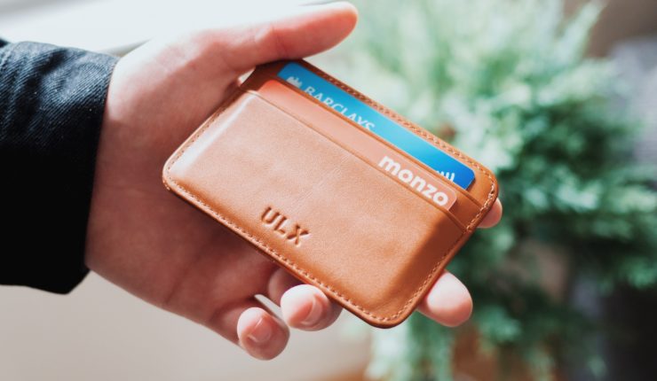 Man holding wallet with Monzo and Barclays cards